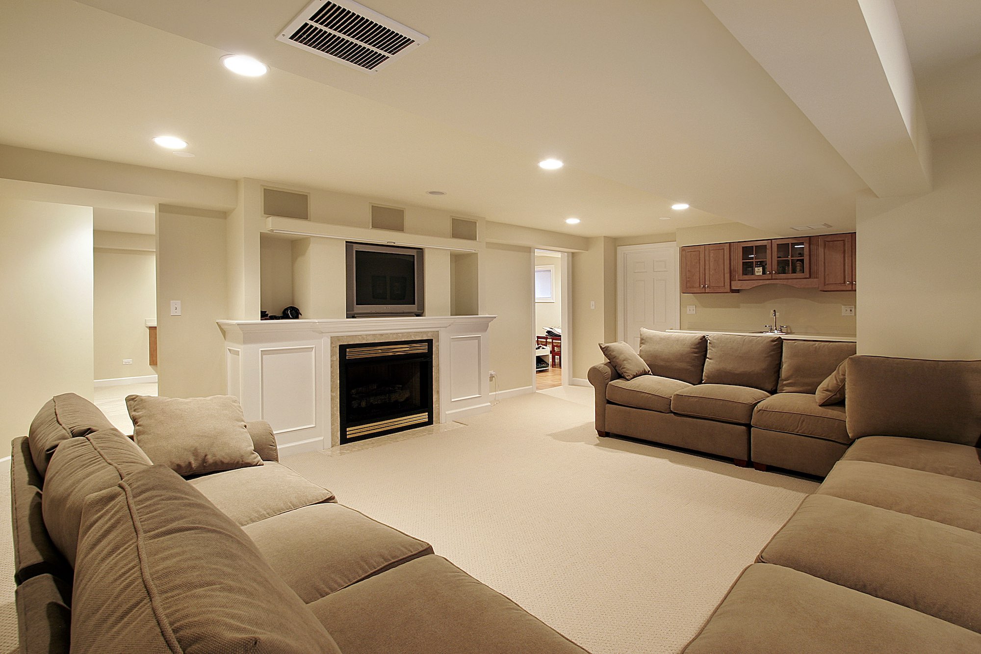Basement in luxury home with white fireplace